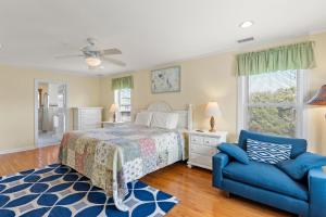 a bedroom with a bed and a blue chair at Sounds Like A Plan in Kill Devil Hills