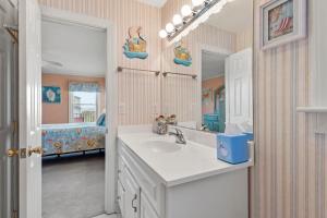 a bathroom with a sink and a mirror at Sounds Like A Plan in Kill Devil Hills +54 photos