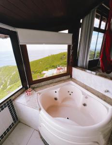 a bath tub in a bathroom with a window at Sentinelas do Mar in Arraial do Cabo +77 photos