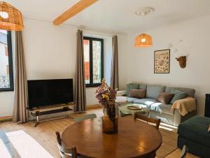 a living room with a couch and a table at Chez flader, deux pièces de 55m2 centre historique in Langeac