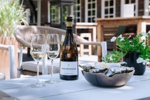 a bottle of wine and two glasses on a table at De Swarte Ruijter in Holten +42 photos