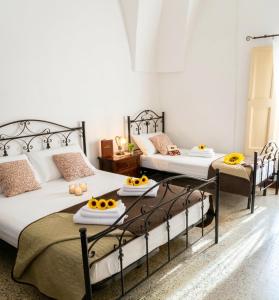 two beds in a room with fruit on the tables at Mercanti in Manduria