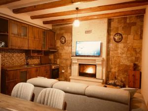 a living room with four chairs and a tv and a fireplace at Vila Alpini in Razëm