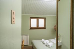 a mirror in a room with a bed and a window at Achada do Teixeira Mountain Spot Lodge in Santana