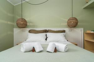 a bedroom with a bed with three towels on it at Achada do Teixeira Mountain Spot Lodge in Santana
