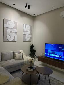 a living room with a couch and a tv at شقة اند هوم in Hail