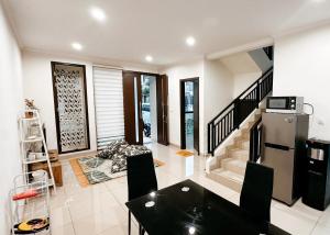 a kitchen with a refrigerator and a table and chairs at Lee Simple House - Summarecon Bandung in Tegallebu