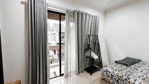 a bedroom with a bed and a large window at Lee Simple House - Summarecon Bandung in Tegallebu +48 photos