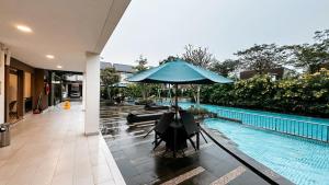 a blue umbrella sitting next to a swimming pool at Lee Simple House - Summarecon Bandung in Tegallebu