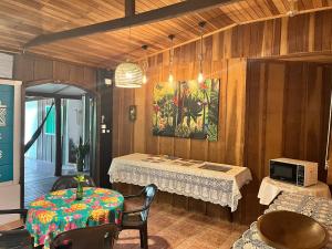a dining room with a table and a microwave at Tekoah Pousada in Paranaguá