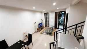 a living room with a staircase and a television at Lee Simple House - Summarecon Bandung in Tegallebu