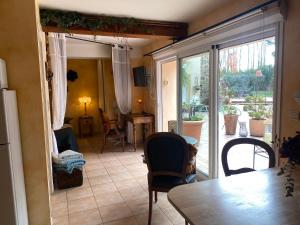 a living room with a table and chairs and a sliding glass door at "MAS TRAMONTANE" Maison et Chambres d'hôtes avec vue sur le massif d'El Canigó in Ille-sur-Têt