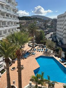 an aerial view of a pool with palm trees and chairs at Blue Ocean Costa Adeje 502 in Playa de las Americas