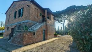 a brick building with a staircase on the side of it at Casa Algherini in Borghetto