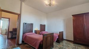 a bedroom with two beds with pink sheets and a mirror at Casa Algherini in Borghetto +8 photos