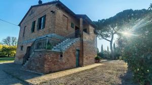 a brick building with a staircase on the side of it at Casa Algherini in Borghetto
