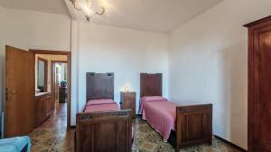 a bedroom with two beds and wooden cabinets at Casa Algherini in Borghetto