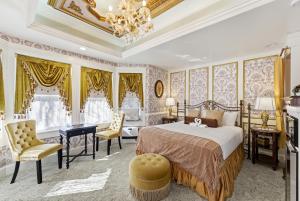 a bedroom with a bed and chairs and a chandelier at Heber Senator Bed and Breakfast in Heber City