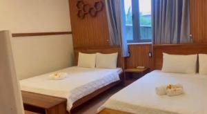 two beds in a small room with a window at Sao Biển Phú Quốc in Phú Quốc