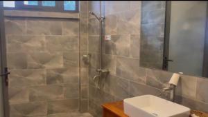 a bathroom with a shower with a sink and a mirror at Sao Biển Phú Quốc in Phú Quốc