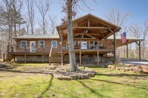 a large wooden house with a porch and an american flag at 'Bullfrog Bluff' Mountain View Cabin w/ Deck! in Mountain View