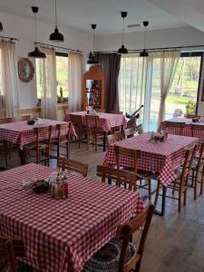 a restaurant with red and white checked tables and chairs at Fruškogorski Đeram in Grgeteg