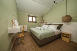 a bedroom with a bed with a chair and a window at Achada do Teixeira Mountain Spot Lodge in Santana +3 photos