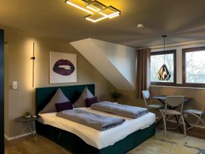a bedroom with two beds and a table and windows at One Seven - BRIGHT Collection in Koblenz