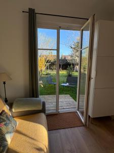 a living room with a sliding glass door to a patio at Gîte les violettes in Lagny
