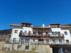 a white building with a balcony on top of it at Hofschank Reinalterhof in Malles Venosta