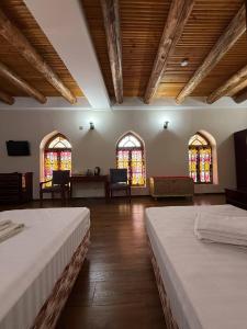 a room with two beds and stained glass windows at SHoxtut INN 18-19Th Century in Bukhara