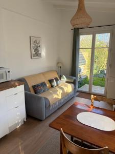 a living room with a couch and a table at Gîte les violettes in Lagny