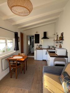 a living room with a table and a kitchen at Gîte les violettes in Lagny