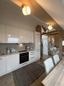 a kitchen with white cabinets and a table and a couch at One Seven - BRIGHT Collection in Koblenz