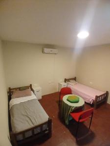 a room with two beds and a table and chairs at La Casona Hostel in Bermejo