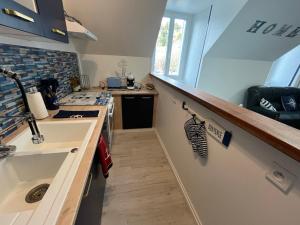 a kitchen with a sink and a counter top at Les Roitelets "MARINE" Appartement T4 Duplex 80m2 - Thème Marin - Entièrement NEUF - Classé 3 étoiles - Proche Centre-ville & Thermes - Tout Confort - Ménage et Linge de maison INCLUS in La Bourboule