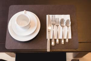 a table with a plate and a cup and spoon at Hotel Sara - Ampere in Ampère