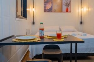 a table with two plates and a bottle of drink at Studio Container - Conforto e Ótima Localização in Sinop