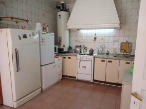 a kitchen with white appliances and white cabinets at La Casona Hostel in Bermejo