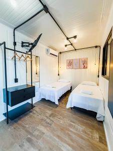 a room with two beds and a mirror at Studio Container - Conforto e Ótima Localização in Sinop