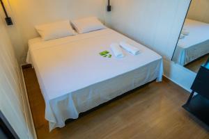 a small bed with two white towels on it at Studio Container - Conforto e Ótima Localização in Sinop