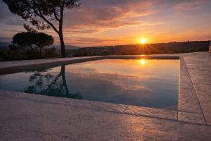 a swimming pool with the sunset in the background at B&B Villa Elianto in Notaresco