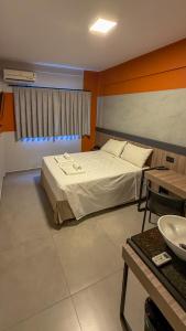 ein Hotelzimmer mit einem Bett und einem Tisch in der Unterkunft Hotel Coroados Foz Express in Foz do Iguaçu