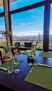 a table with wine glasses on it with a view at Хотел Магура in Rabisha