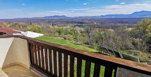 a wooden balcony with a view of the mountains at Хотел Магура in Rabisha +2 photos