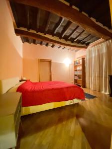 a bedroom with a bed with a red blanket at la casa d'oro in Arezzo