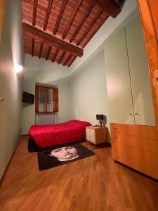 a bedroom with a red bed and a wooden floor at la casa d'oro in Arezzo