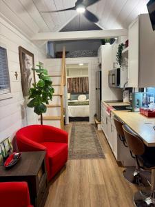 a living room with a red chair and a kitchen at Horseshoe Tiny home in Scottsdale
