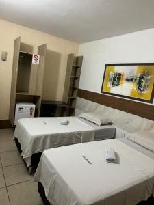 a hospital room with two beds and a picture on the wall at Hotel orla House in Petrolina