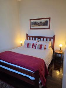 a bedroom with a large bed with two lamps at The Gympie Empire in Gympie
